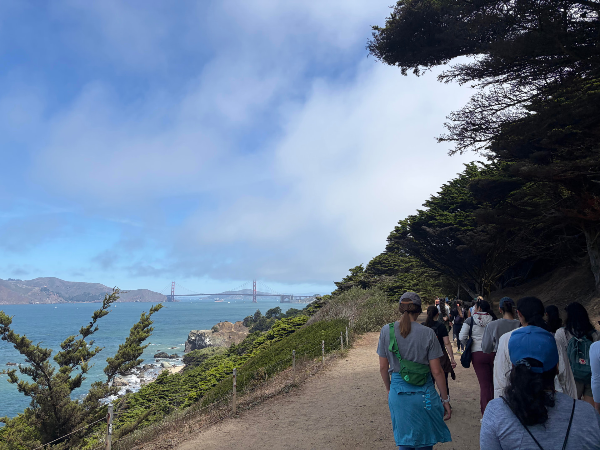 Climate Gals hiking along the California coastline with the Golden Gate Bridge in the distance